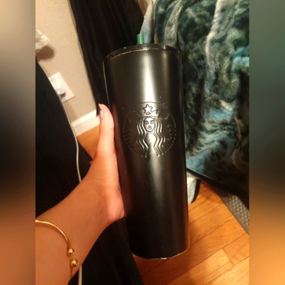 Black Starbucks cup with green straw